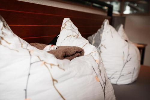 a teddy bear laying on a bed with pillows at Unterkunft KemptenCityHost in Kempten