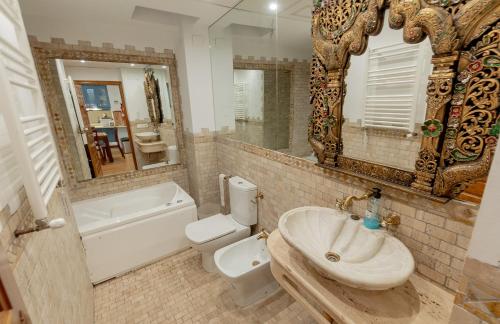 y baño con lavabo, aseo y espejo. en SUAY Apartments, en Sevilla