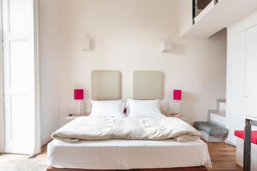 a white bed with a white bedspread and pillows at Micalò Art Rooms in Naples
