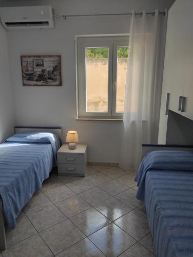 1 Schlafzimmer mit 2 Betten und einem Fenster in der Unterkunft Appartamento Panorama sul mare in Tropea
