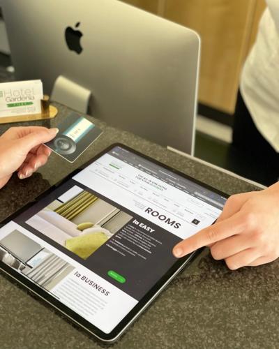 a person pointing at an ipad on a table at Hotel Gardenia Fiera in Cermenate