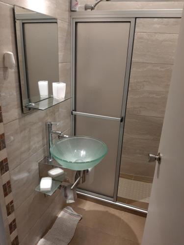 y baño con lavabo verde y ducha. en Apartamento con entrada independiente y jardín, en Punta del Este