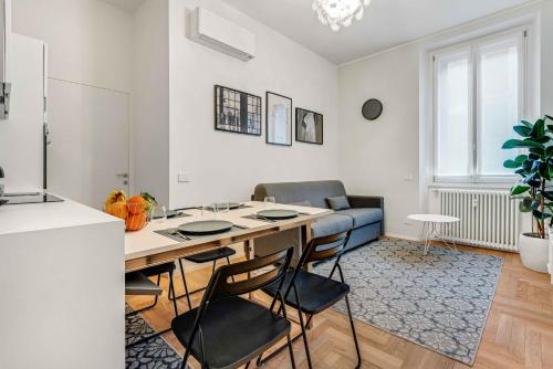 uma cozinha e sala de estar com mesa e cadeiras em New Milan Central Apartment em Milão