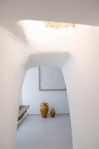 a white room with two vases on the floor at Je T'aime Luxury Suite and Relax in Conversano