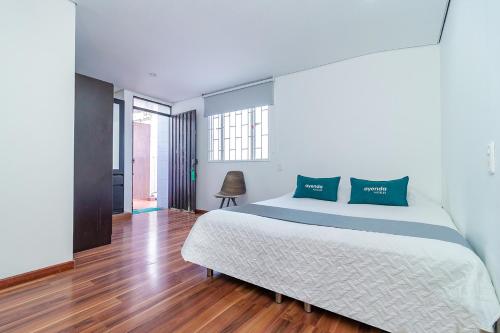 1 dormitorio con 1 cama grande y suelo de madera en Ayenda 1079 Bogotá Alpes Polo Club, en Bogotá