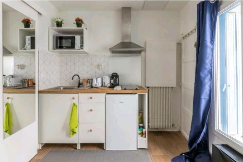 una pequeña cocina con fregadero y encimera en Studio Puteaux Paris-Defense by Servallgroup, en Puteaux