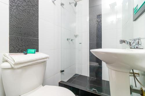 een witte badkamer met een toilet en een wastafel bij Ayenda 1079 Bogotá Alpes Polo Club in Bogota