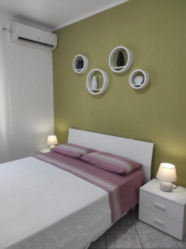 a bedroom with a bed with three mirrors on the wall at Appartamento Panorama sul mare in Tropea