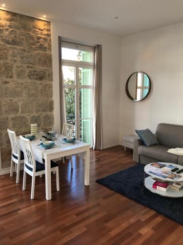 un salon avec une table et un canapé dans l'établissement Menton vue jardins Biovès spacieux 2 pièces 52m2 en hypercentre, à Menton