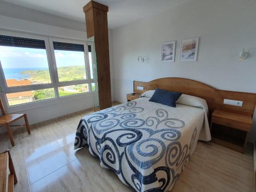ein Schlafzimmer mit einem Bett und einem großen Fenster in der Unterkunft Apartamentos Rozas Vellas in Sanxenxo