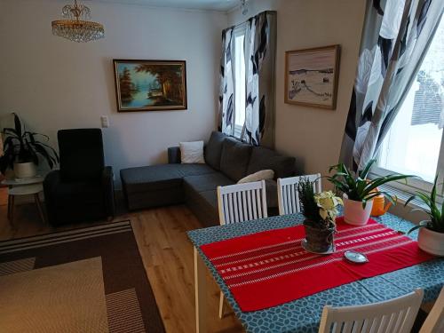uma sala de estar com uma mesa e um sofá em FirstHome GuestHouse em Pietarsaari