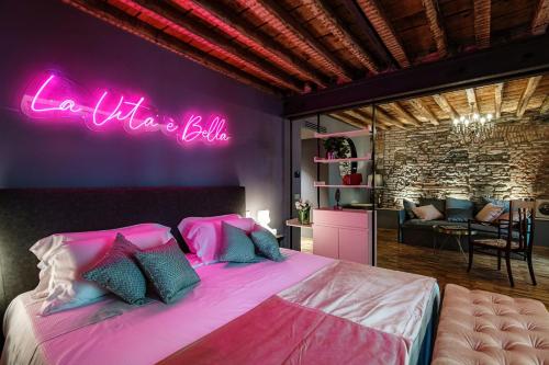 a bedroom with a large bed with a neon sign at Vitrum - Como Luxury Suites in Como