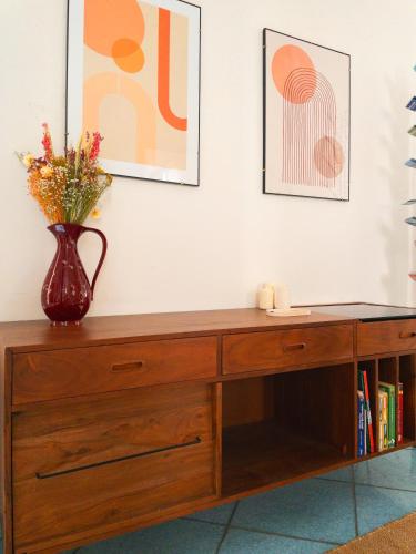 un vase de fleurs assis au-dessus d'un meuble en bois dans l'établissement Maison Trenca, à Menton