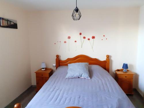 - une chambre dotée d'un lit avec des draps bleus et des fleurs sur le mur dans l'établissement Maison charmante à Saint-Blimont avec jardin, à Saint-Blimont