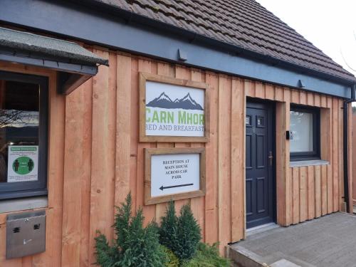 a building with a sign on the side of it at Carn Mhor Bed and Breakfast in Aviemore