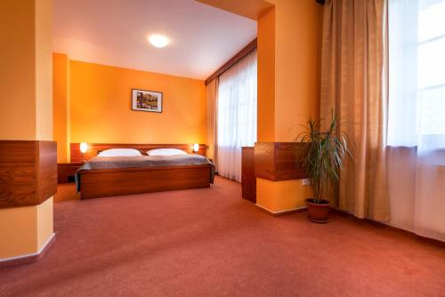 a bedroom with orange walls and a bed and a window at Hotel SKANZEN in Velehrad