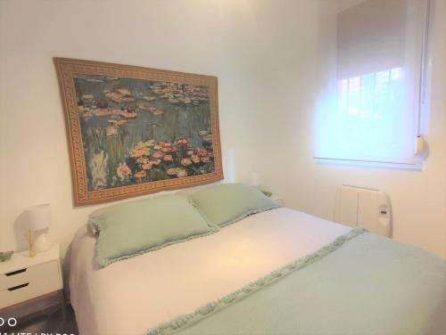 a bedroom with a bed with a painting on the wall at Apto IBAIONDO-Con encanto, céntrico y comunicado in Bilbao