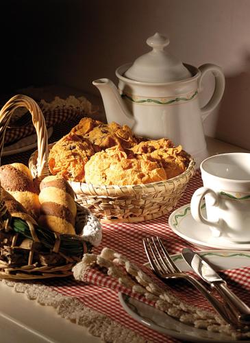 a table with two baskets of bread and a tea pot at Hotel La Locanda Dei Ciocca in Grottaferrata