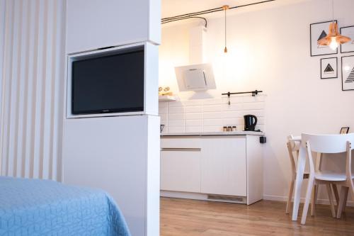 a kitchen with a bed and a tv in a room at Check in Szczecin in Szczecin