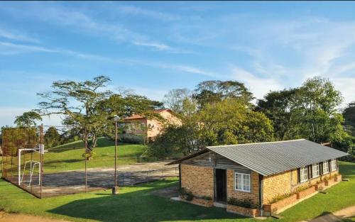 a small brick house in a yard with a basketball hoop at POUSADA PÔR DO SOL in Ipiabas