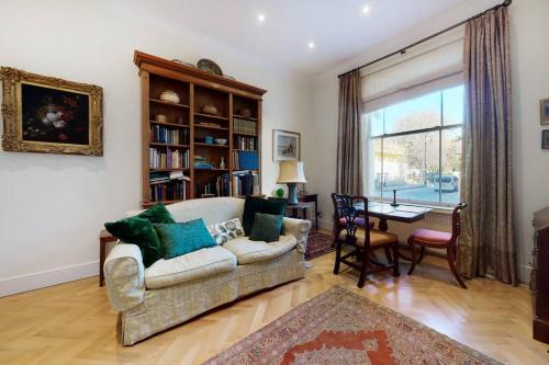 uma sala de estar com um sofá e uma mesa em Lovely 1 bedroom flat in Pimlico em Londres
