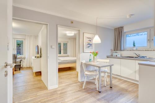 eine Küche und ein Wohnzimmer mit einem Tisch und Stühlen in der Unterkunft AchterHuus in Norderney