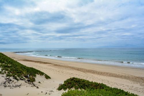 a sandy beach with the ocean in the background at 4 Zwaan in Jeffreys Bay