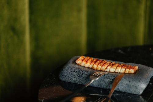 a piece of food on a grill with a fork at Radisson Collection Hotel, Magdalena Plaza Sevilla in Seville