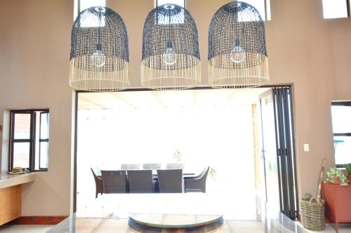 a dining room with a table and some bird cages at 4 Zwaan in Jeffreys Bay