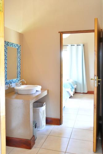 a bathroom with a sink and a mirror at 4 Zwaan in Jeffreys Bay