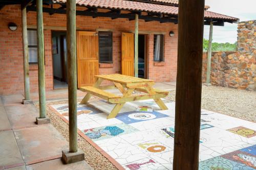 a wooden picnic table in front of a building at 4 Zwaan in Jeffreys Bay