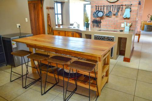 a kitchen with a wooden table and some stools at 4 Zwaan in Jeffreys Bay