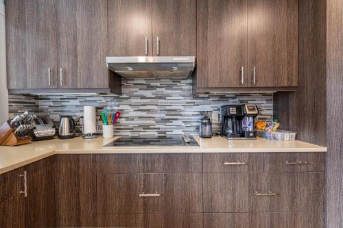 a kitchen with wooden cabinets and a counter top at Private Hot Tub - Private Front Yard with Mountain View Patio in Canmore