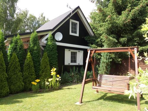 a house with a bench in front of a yard at White & Black in Kołczewo