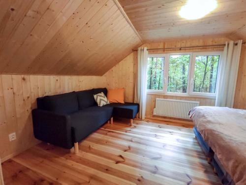 a room with a couch and a bed in a cabin at Konwaliowe Zacisze - chillout w leśnej aurze in Wilga