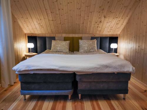 a bedroom with a large bed with two lamps on tables at Konwaliowe Zacisze - chillout w leśnej aurze in Wilga