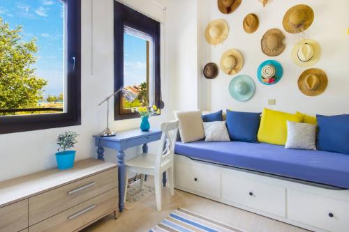 a blue couch in a room with a desk and a window at Ekavi Villa in Skala Potamias