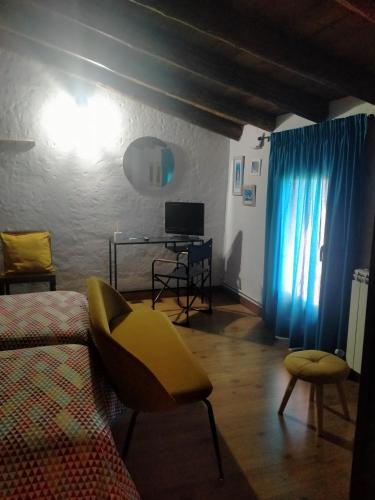 a living room with a bed and a desk in it at Hotel Rural El Cielo Entejado in Tejado
