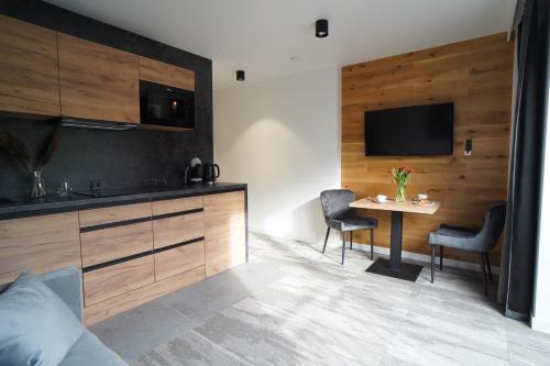 a kitchen and dining room with a table and a television at Beskidzka9 & Free Sauna in Szczyrk