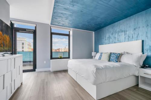 a bedroom with a white bed with a blue ceiling at Global Luxury Suites at The Arches in Bronx