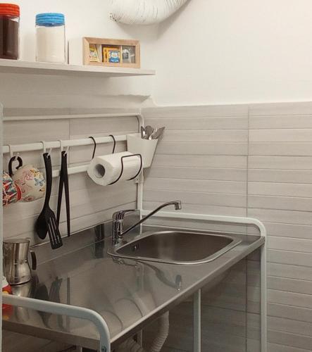 a kitchen with a sink and a shelf with utensils at Vico Trieste in Ostuni