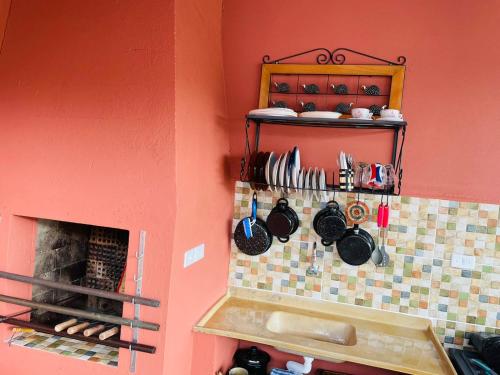 a kitchen with a fireplace and a counter with pots and pans at EcoPousada Perequê - Pontal do Sul in Pontal do Paraná