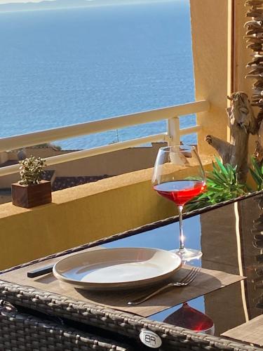 a glass of wine sitting on a table on a balcony at AJACCIO Très beau T2 confortable Sanguinaires in Ajaccio