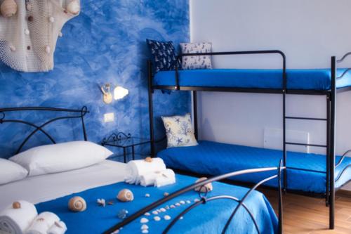 a bedroom with two bunk beds with blue walls at Agriturismo Karrares in Melendugno
