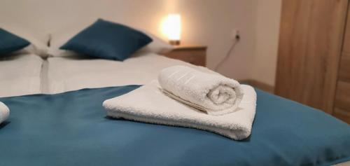 uma pilha de toalhas sentadas em cima de uma cama em Sipos Vendég és Apartmanház em Balatongyörök