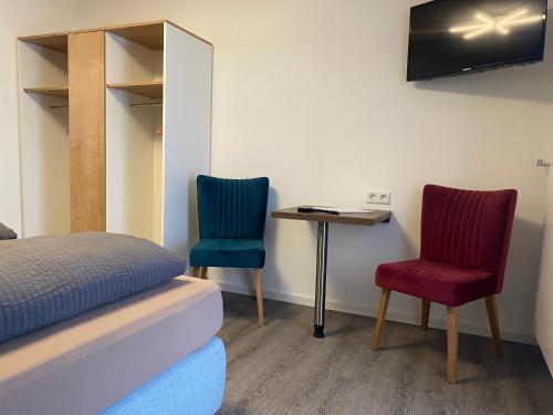 a room with two chairs and a table and a bed at Astrid's Pension in Winterberg