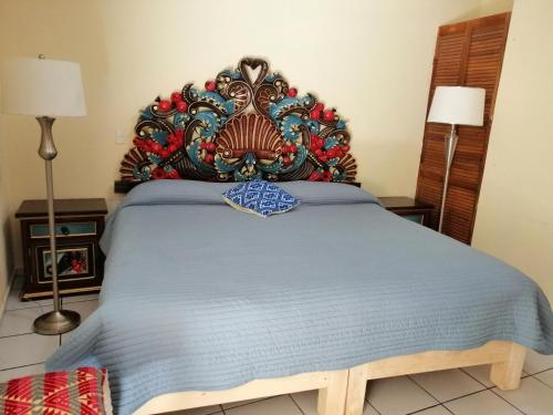 a bed with a large headboard in a bedroom at Hotel Chely in Bernal