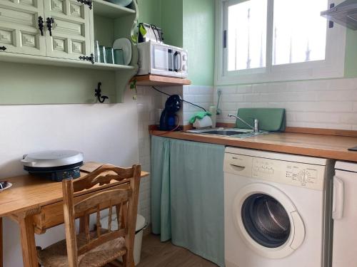 a kitchen with a washing machine and a sink at La Casita Tipica in Zuheros