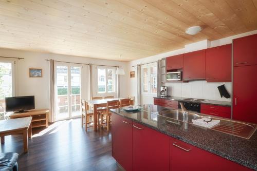 a kitchen with red cabinets and a dining room at CityChalet in Interlaken