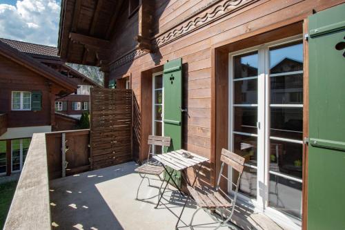 a patio with two chairs and a table and a door at CityChalet in Interlaken